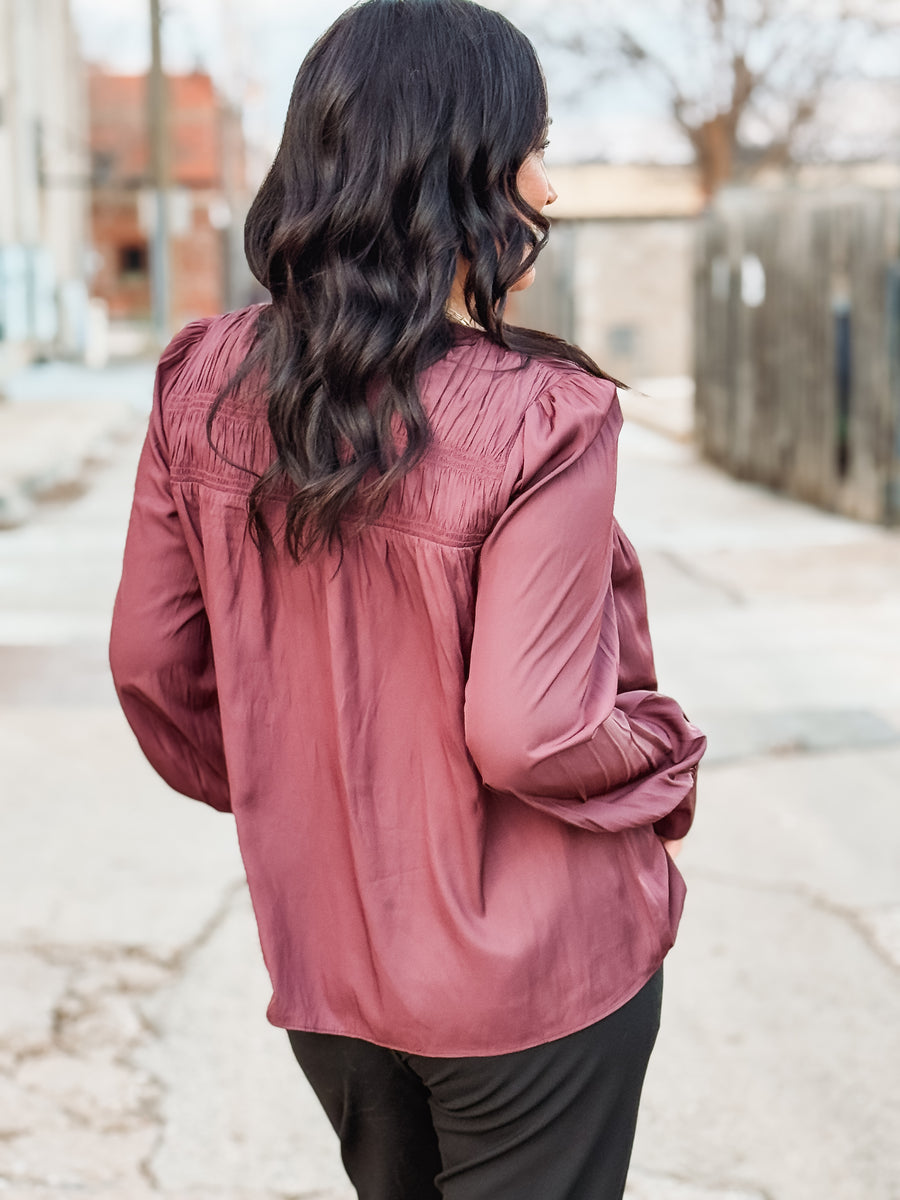 Plum pleated satin long sleeve blouse with back detailing.