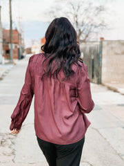 Plum pleated satin long sleeve blouse with back detailing.