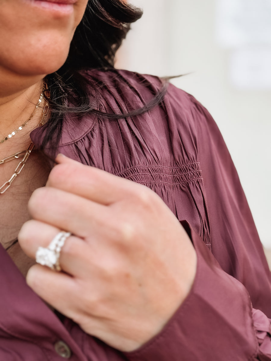 Plum pleated satin long sleeve blouse with back detailing.