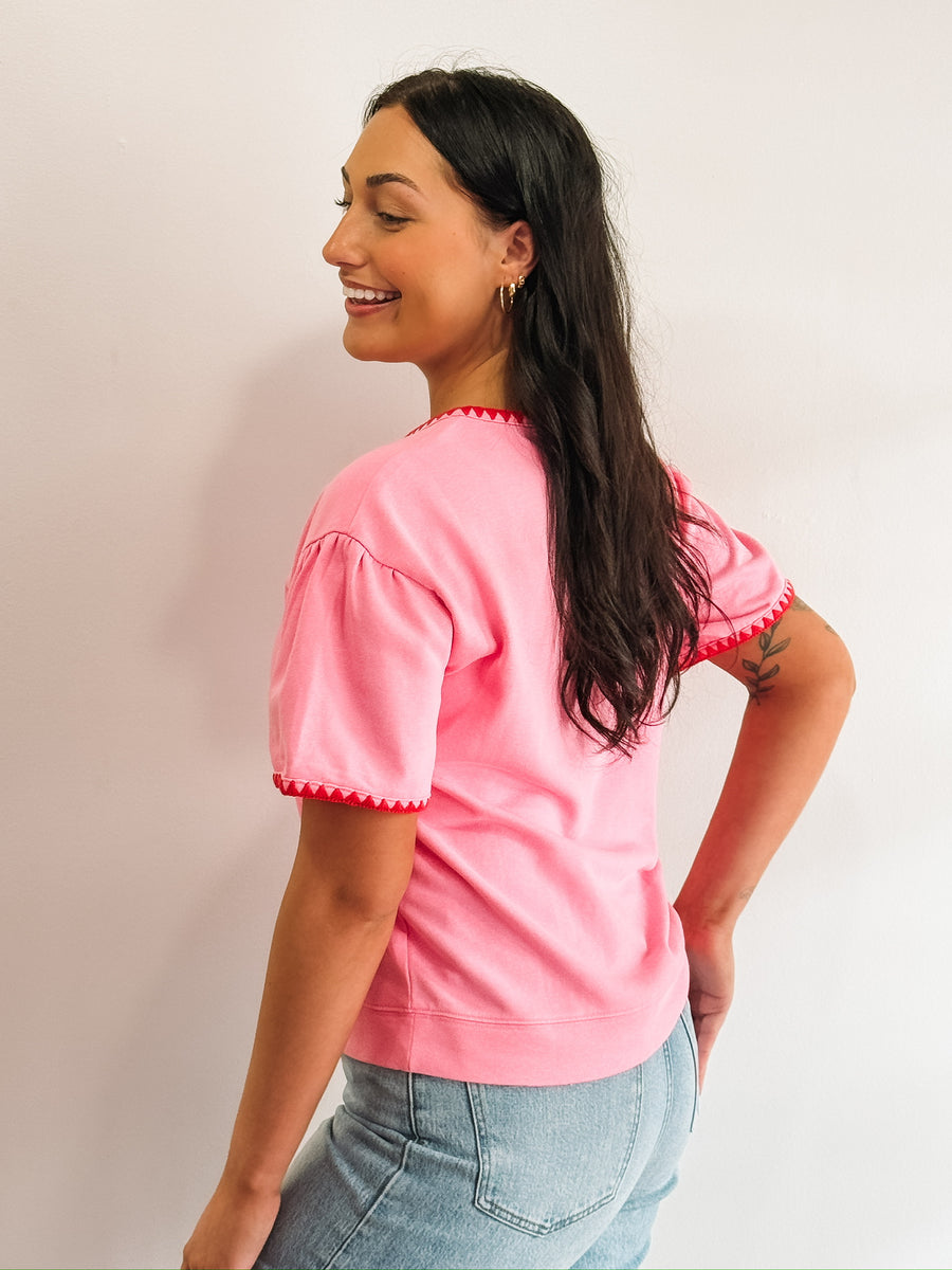 Pink short sleeve tee with red triangle piping.