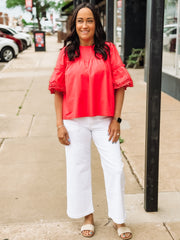 woman wearing red blouse on sidewalk