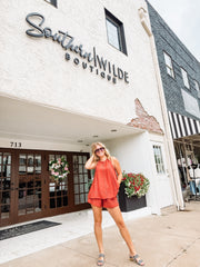 Woman in an orange outfit standing in front of the Southern Wilde Boutique.