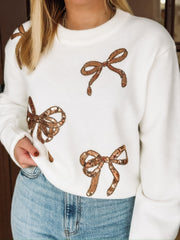 White long sleeve sweater with copper sequin bow motif.
