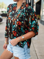 Black short sleeve floral v neck with elastic sleeves and orange and green detailing.