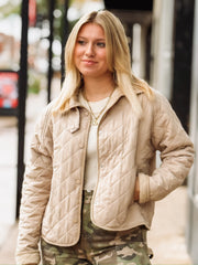 Snap button oatmeal colored jacket that has a quilted design.