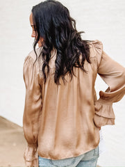 Tan satin long sleeve blouse with bell sleeves and studded detailing.