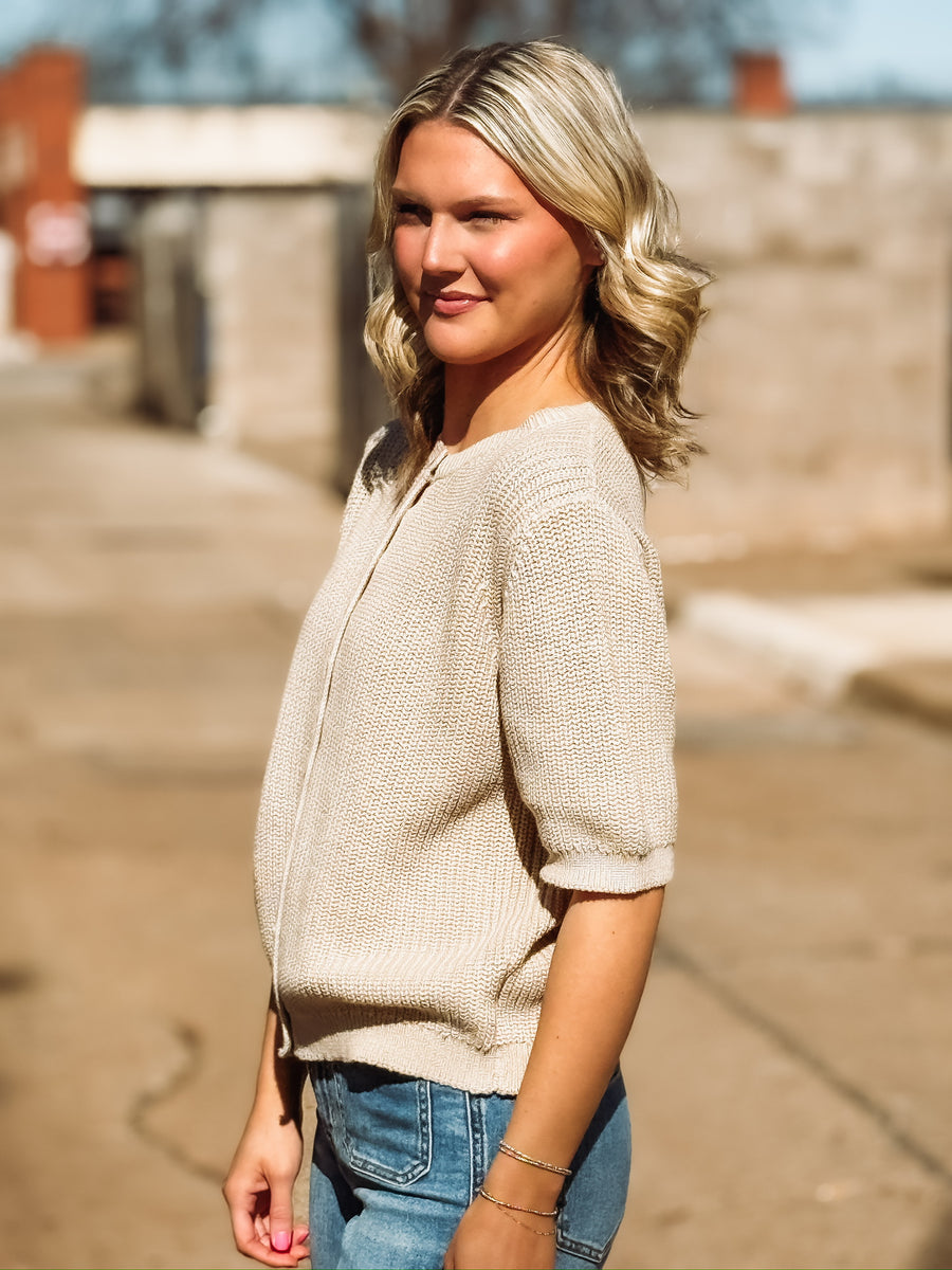 Knitted taupe half sleeve sweater with. a full button front and a crew neckline