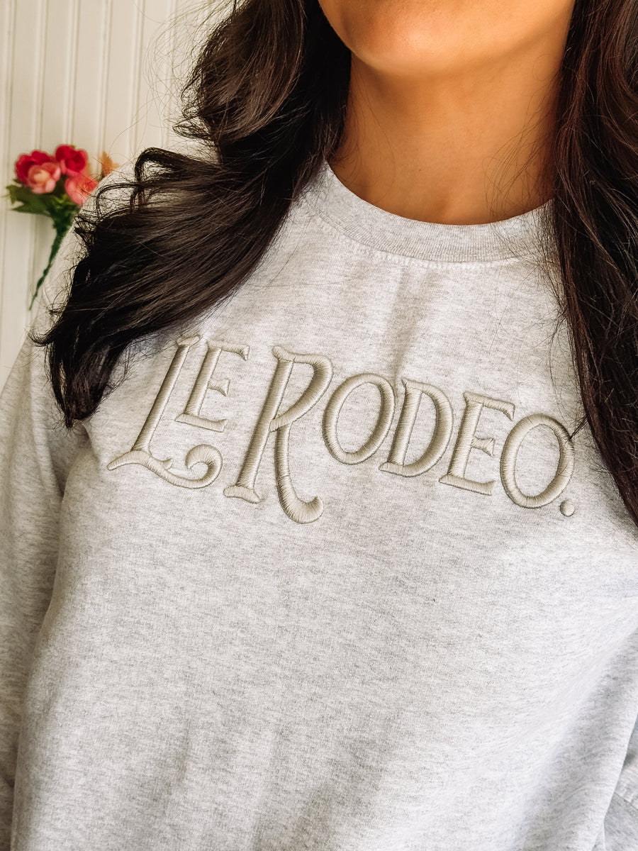 Washed gray crewneck sweatshirt with "Le Rodeo" typography