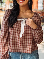 Brick and cream plaid long bubble sleeve top with a square smocked neckline and a self tie bow detail.
