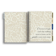 Open notebook with floral design and inspirational quote on a white background
