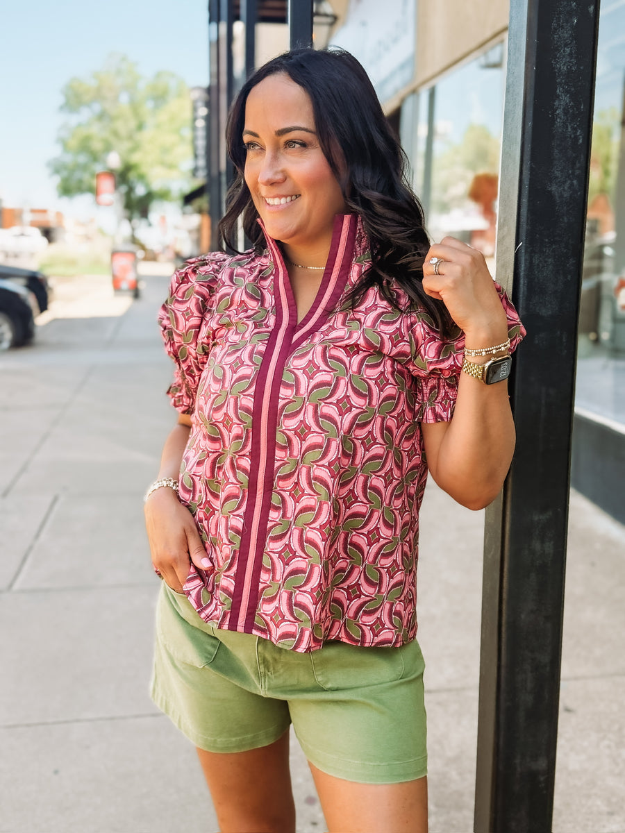 Blouse with a band collar with a wine, pink, and olive colored geometric print