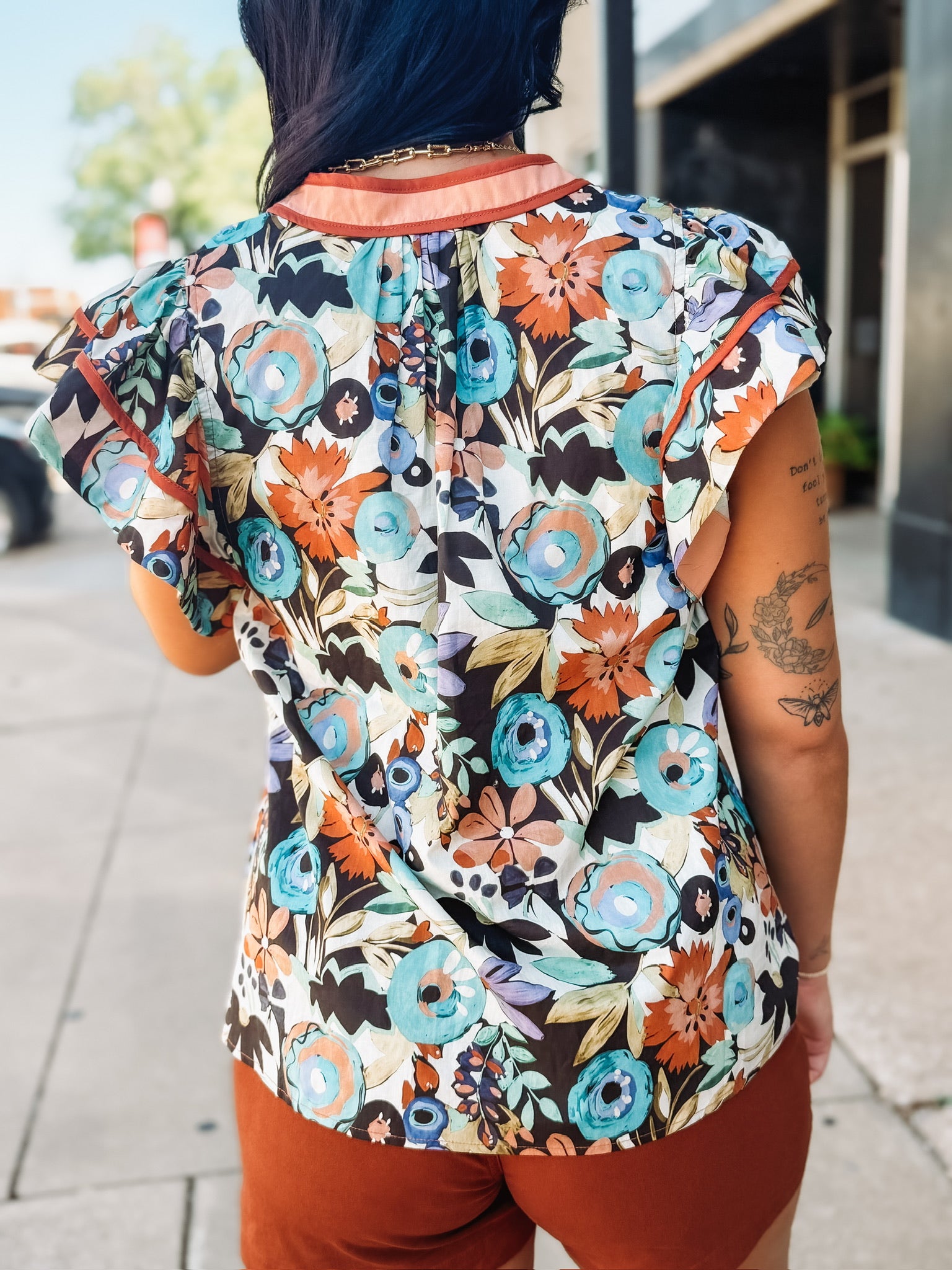 Flutter cap sleeve floral top with orange contrast seaming.