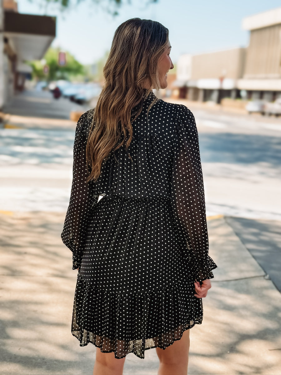 Black long sheer sleeved mini dress with a ruffle button up design.