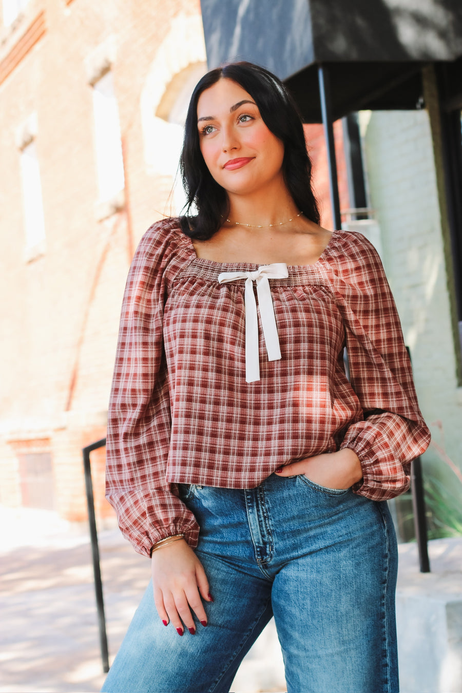 Brick and cream plaid long bubble sleeve top with a square smocked neckline and a self tie bow detail.