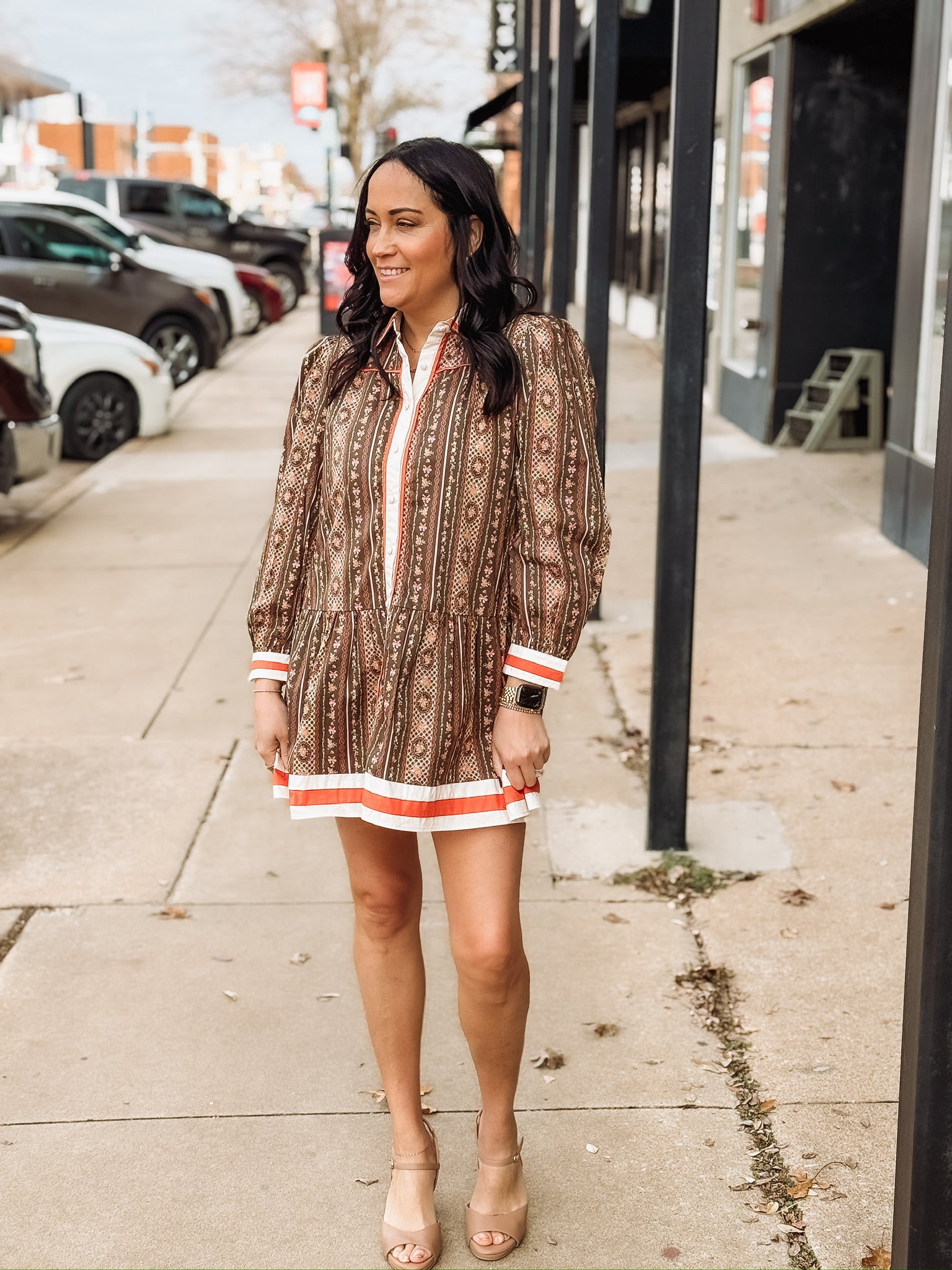 Brown long-sleeve printed mini dress with orange and white trim.