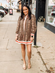 brown long-sleeve printed mini dress with orange and white trim.