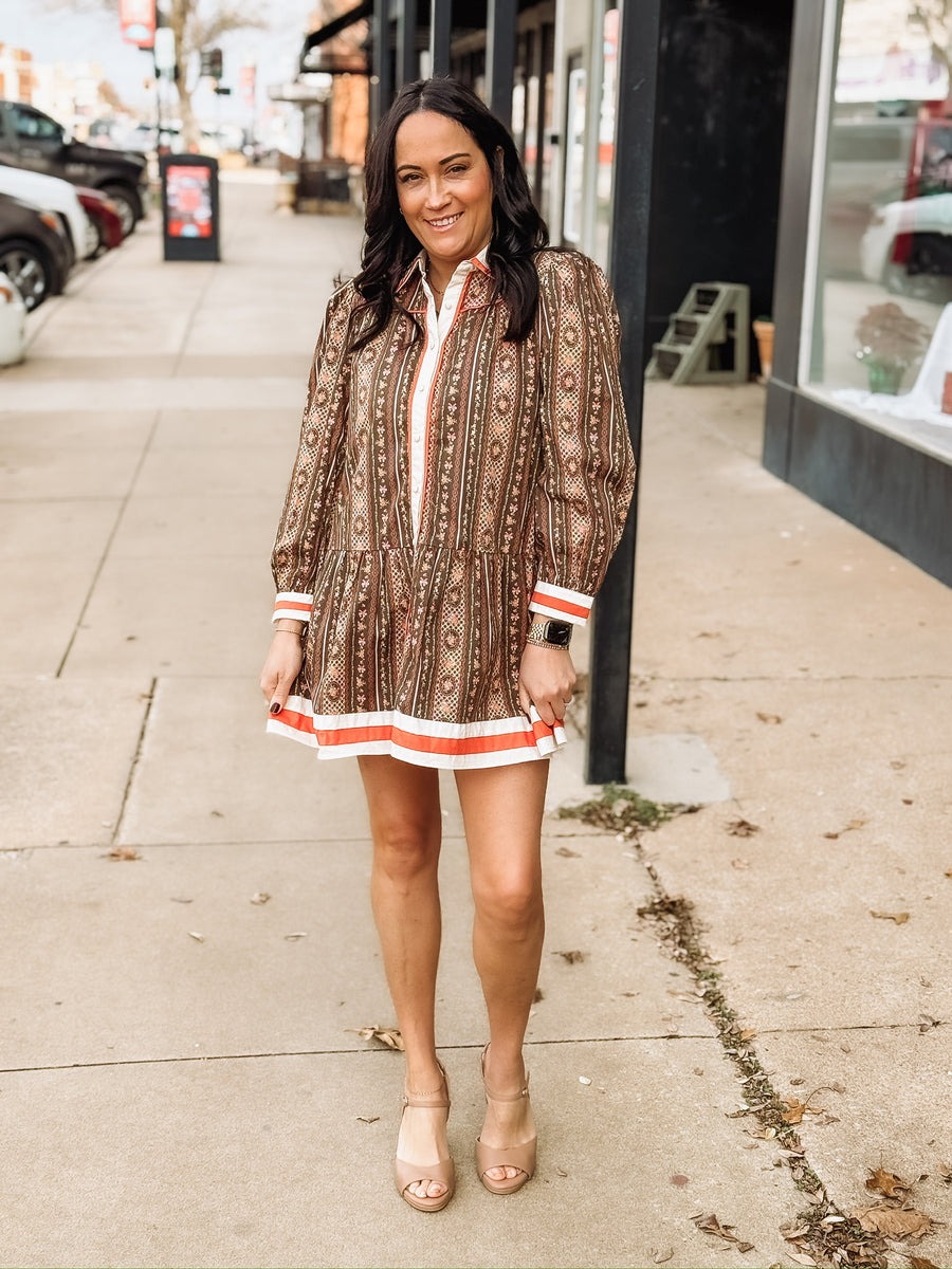 brown long-sleeve printed mini dress with orange and white trim.