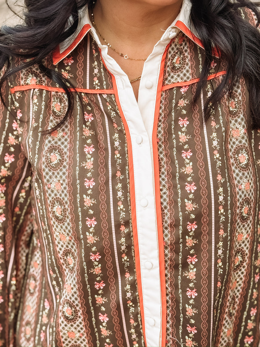 brown long-sleeve printed mini dress with orange and white trim.