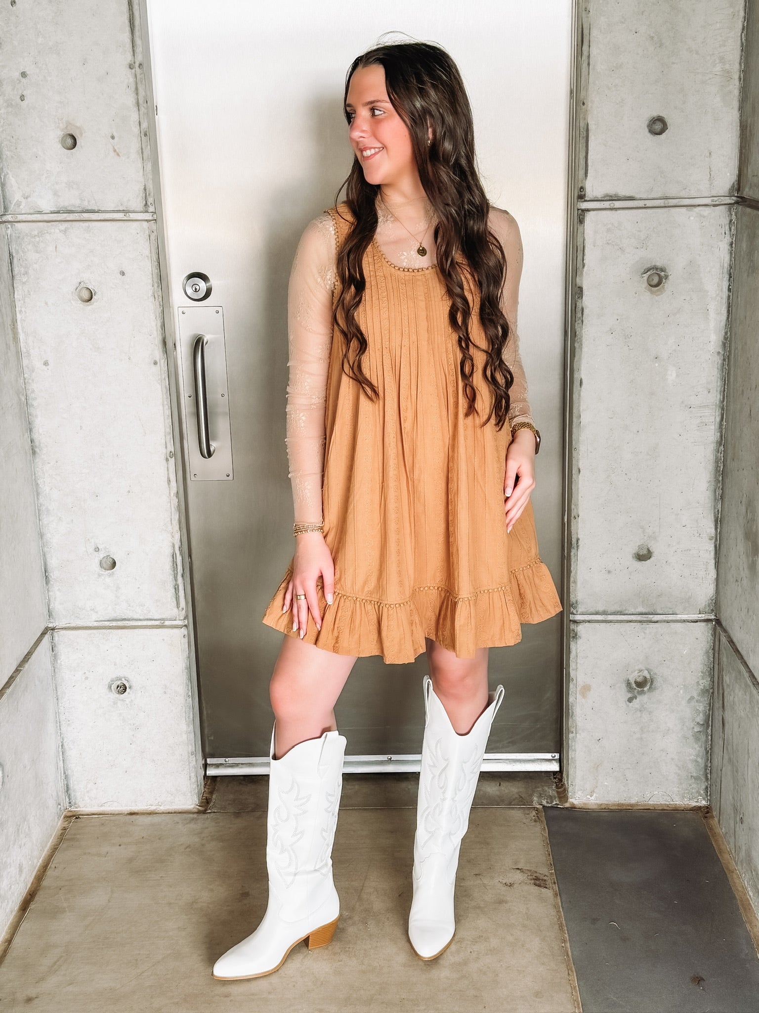 Camel colored embroidered sleeveless mini dress with ruffle hem and pleated detailing.