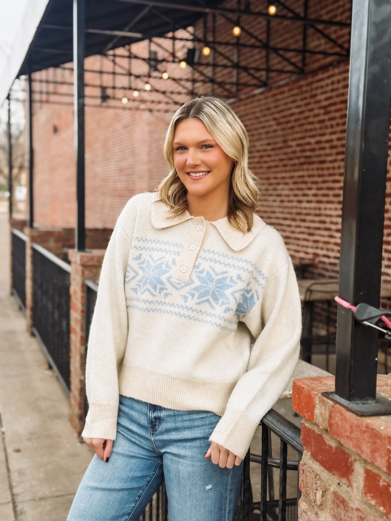 Collared cream long sleeve sweater with button detailing and a light blue fair isle design with snowflakes.