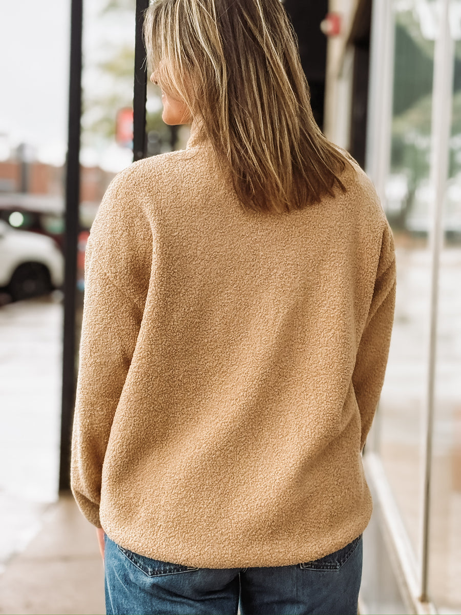 Tan sherpa quarter-zip pullover with front pockets.