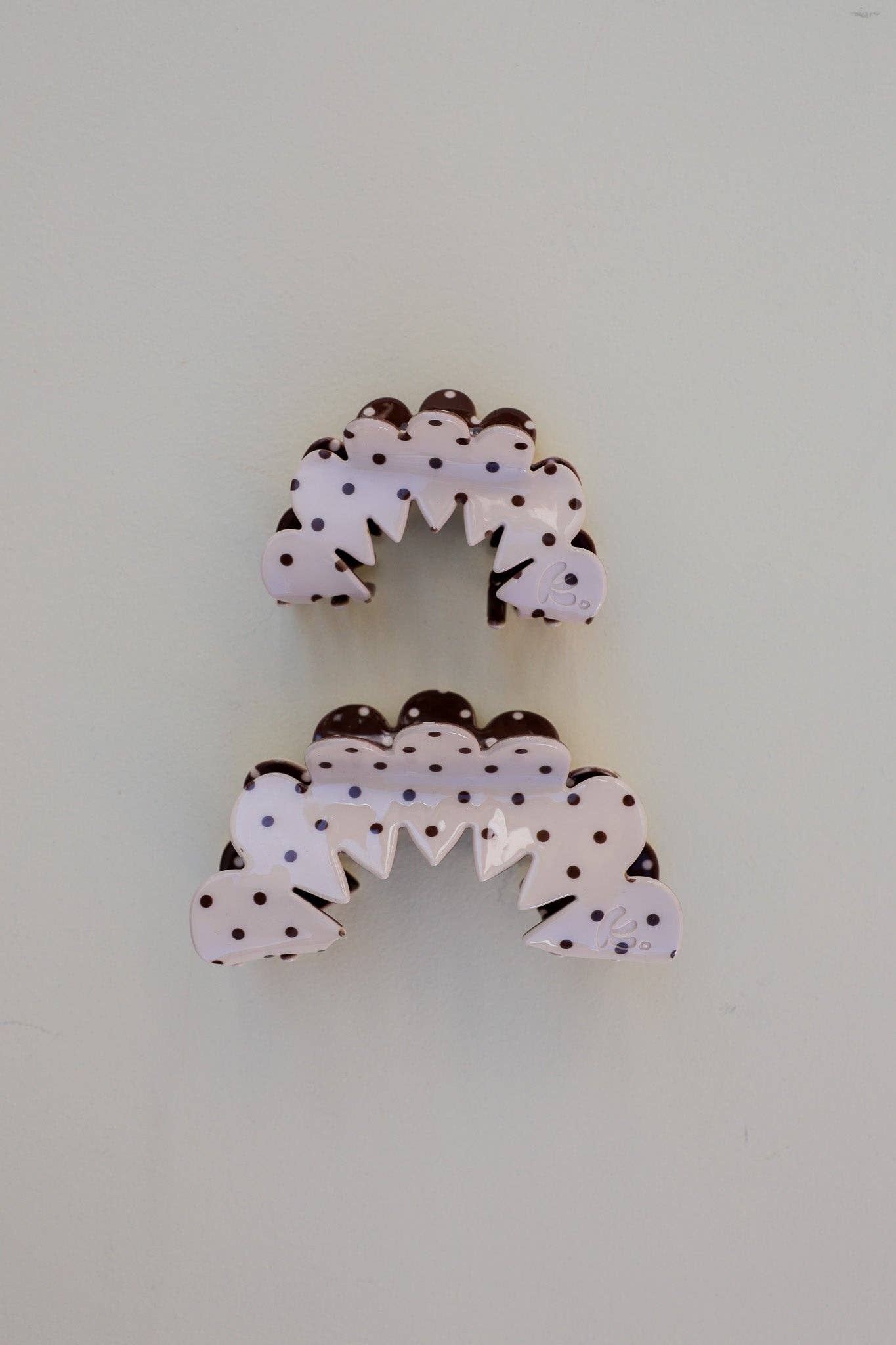 Decorative hair claws with polka dot design on a cream background