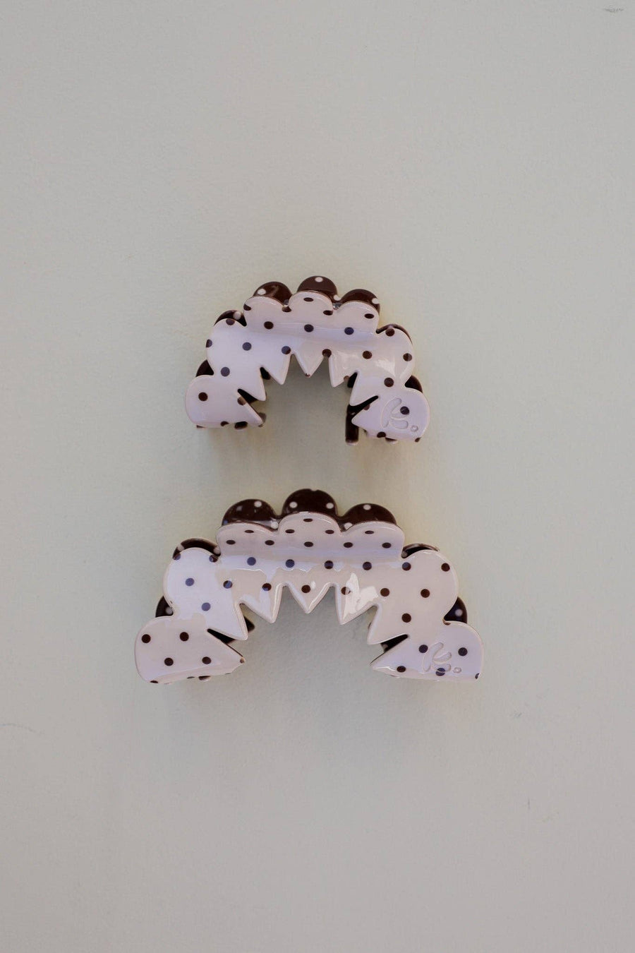 Decorative hair claws with polka dot design on a cream background