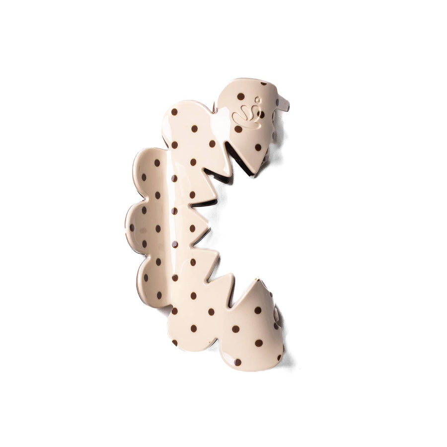 Decorative hair claw with polka dot design on a cream background