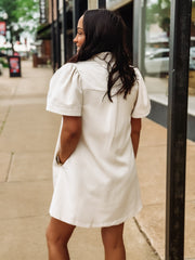 woman on sidewalk in cream tonal dress
