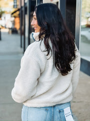 Cropped cream sherpa jacket with denim detailing on zipper and front pockets.
