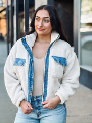 Cropped cream sherpa jacket with denim detailing on zipper and front pockets.