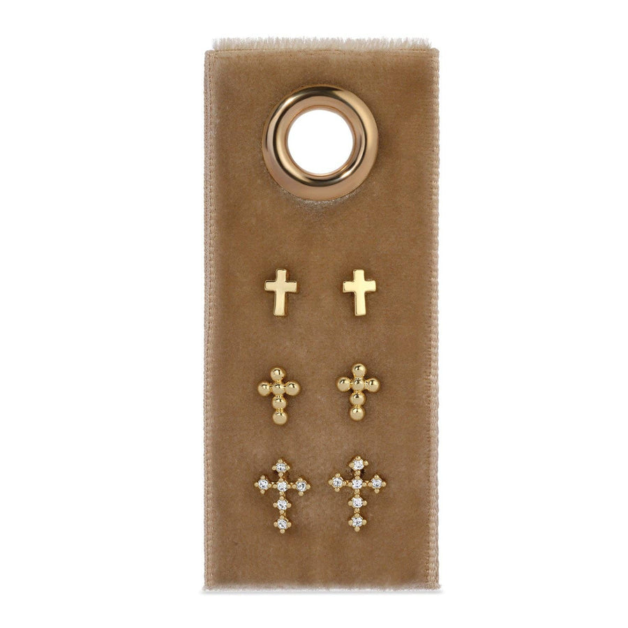 Set of gold cross earrings on a brown card with a gold ring.