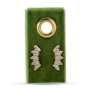 Gold and clear baguette stud earrings on a green earring card with a gold ring.