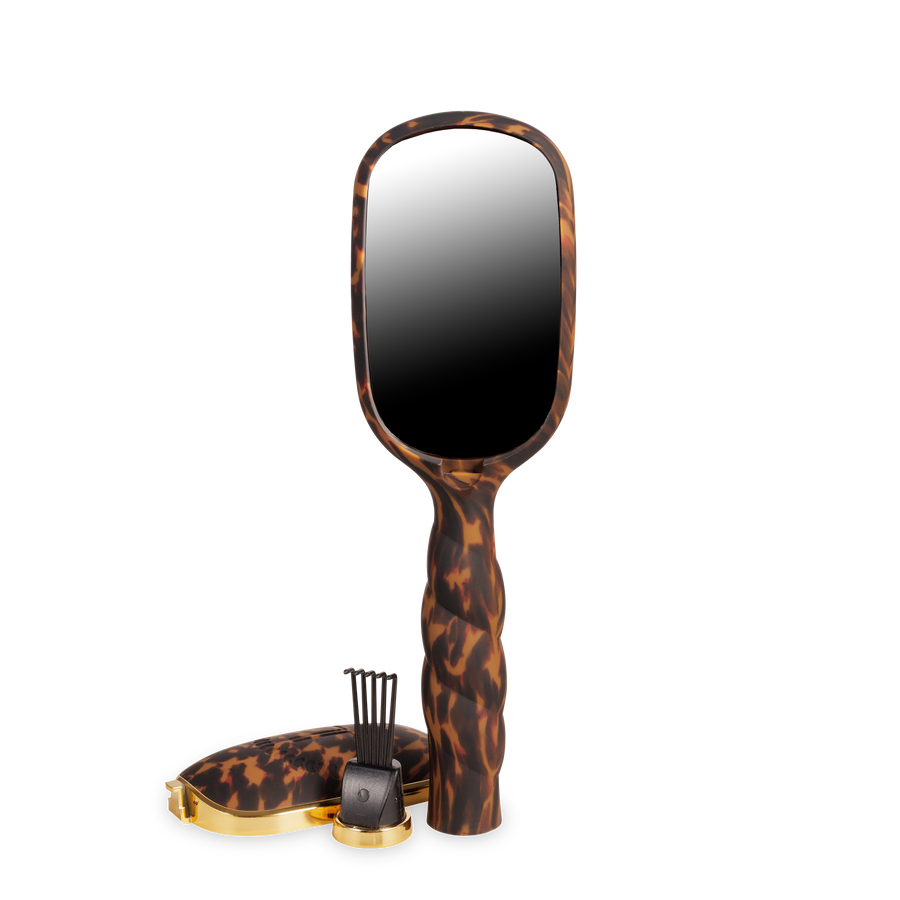 Handheld mirror with tortoiseshell handle on a white background