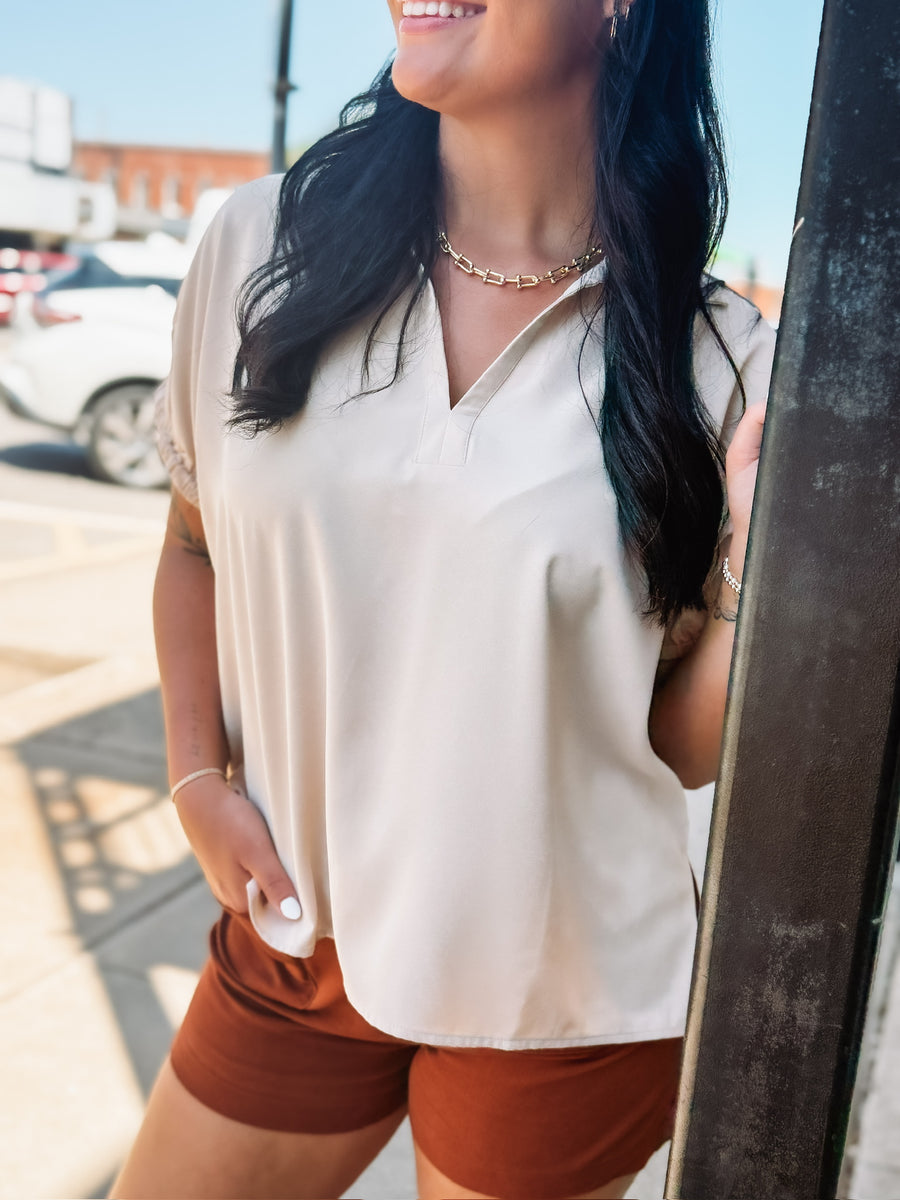 Lightweight collared blouse with elastic short sleeves and a relaxed fit.