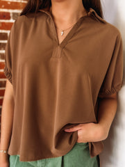 Lightweight collared blouse with elastic short sleeves and a relaxed fit.