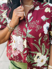 Wine-colored floral blouse with a ruffle neckline and button-up front