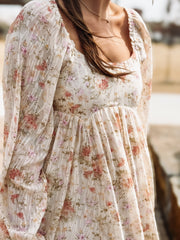 Floral dress with sheer sleeves worn by a person, blurred background