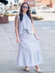 Woman wearing a blue and white checkered dress on a city street.