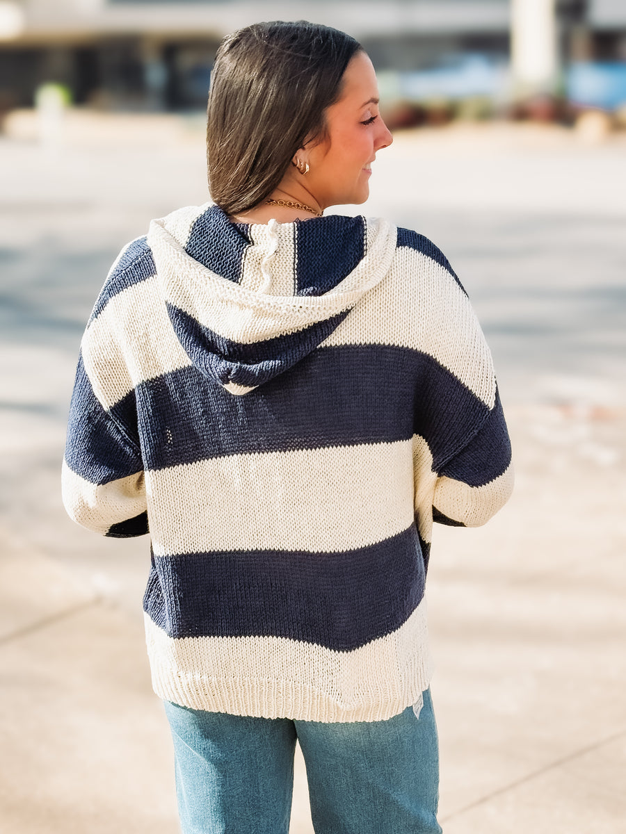 Woman wearing a navy and cream striped hoodie outdoors