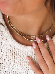 Multi layered gold necklace featuring CZ seperated stones, a cz tennis chain and a thin gold chain.