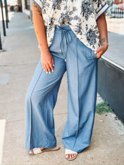 Light blue wide-leg pants with a drawstring waist, front seam detail, and relaxed fit