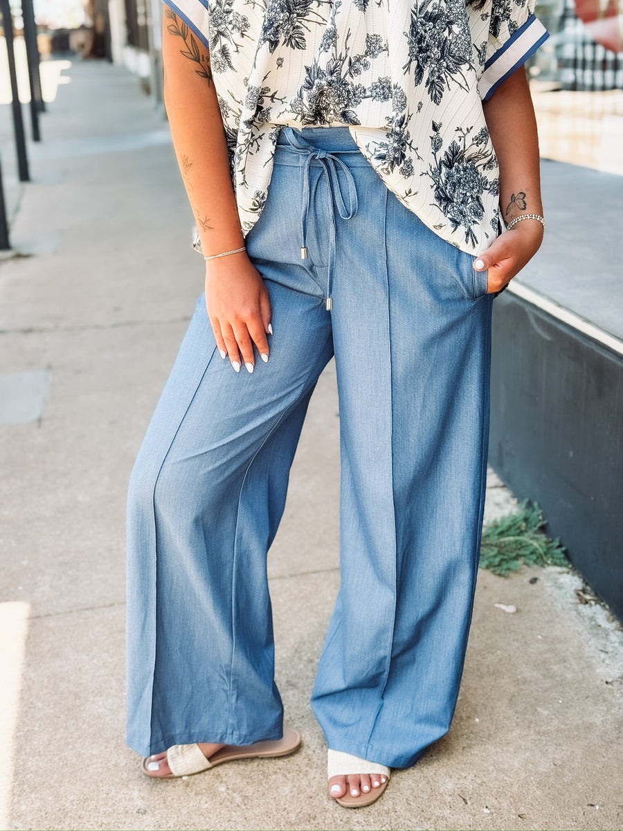 Light blue wide-leg pants with a drawstring waist, front seam detail, and relaxed fit