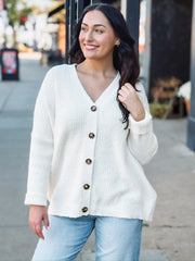 Cream long sleeve oversized cardigan with a v neck and tortoise buttons.