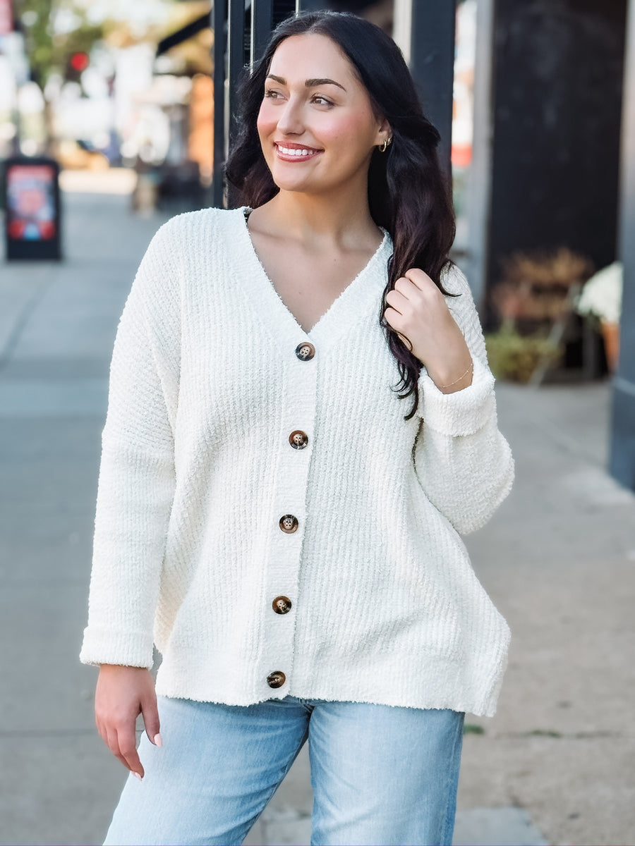 Cream long sleeve oversized cardigan with a v neck and tortoise buttons.