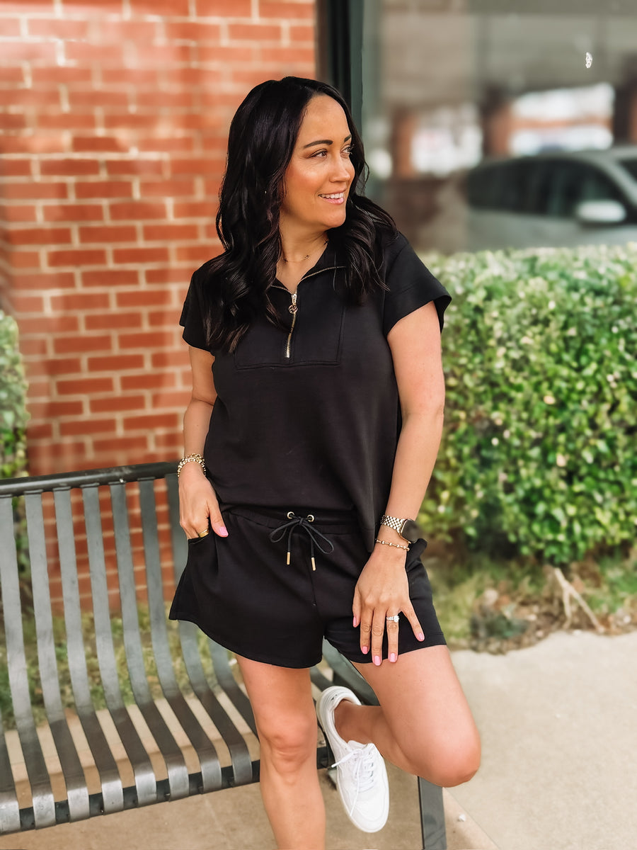 Black short sleeve scuba short set with gold sipper and end cap details from Mary Square.