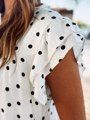 Off white flutter sleeve mini shift dress with black polka dots and a small v neckline.