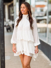 Woman wearing a white dress standing outdoors with blurred background