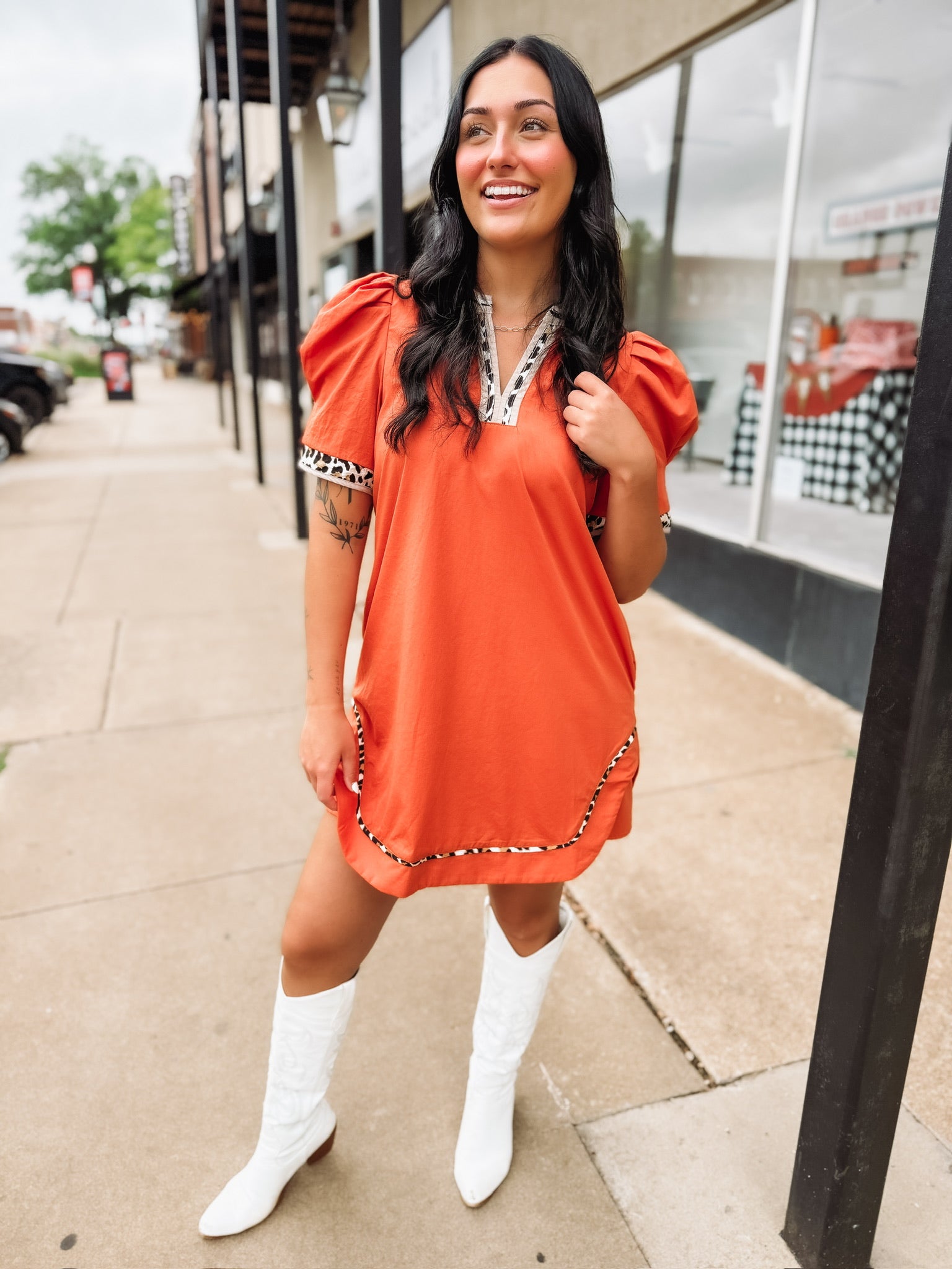 Orange above the knee length dress wit cheetah print trim.