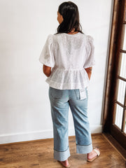 white peplum top with cut out eyelet details and bow tie front